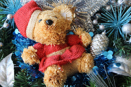 Teddy bear, silvery blue Christmas balls and tinsel on a Christmas wreathの写真素材