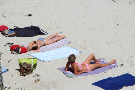 LANDUNVEZ - FRANCE, MAY 26 : Two women in bikini sunbathing on the sand of a beach in Brittany, May 26, 2017のeditorial素材