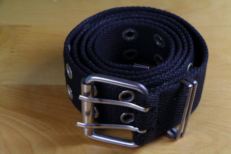 Black fabric belt wind up on a wooden tableの写真素材