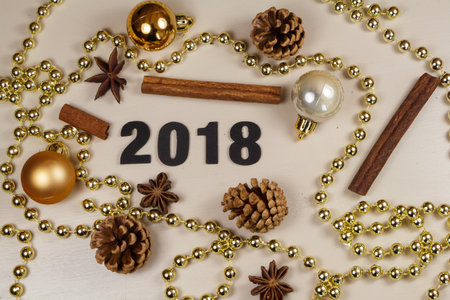 2018, pine cones, cinnamon sticks, star anise, baubles and pearl tinsel as decoration for new yearの写真素材