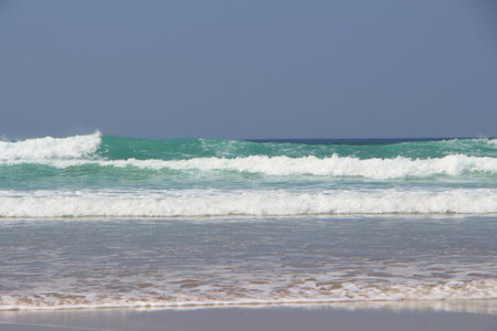 Waves crashing on the sand of a beach in Brittany