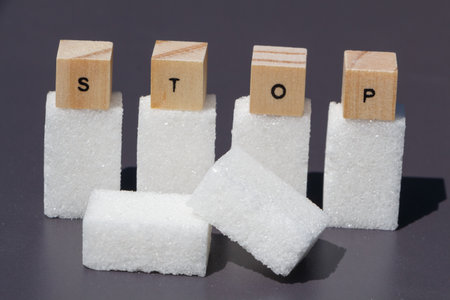 Stop written on wooden cubes and six cubes of sugar