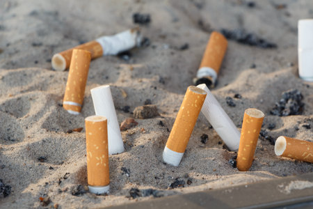 Cigarette butts crushed in the sand of an ashtray