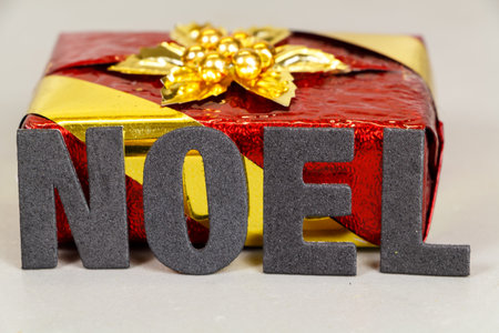 Red and golden gift and the word Christmas written in frenchの写真素材