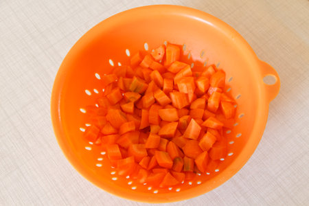 Pieces of carrot in an orange colander
