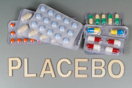Packs of pills and placebo written in wooden lettersの写真素材