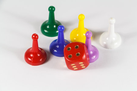 Game pieces of different colors and red dice