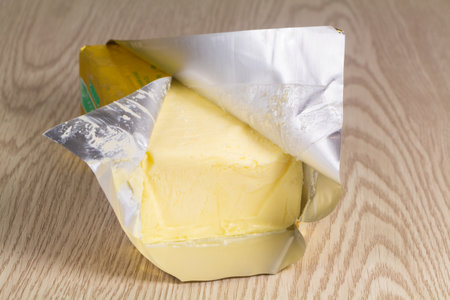 Open pack of salted butter on wooden backgroundの写真素材
