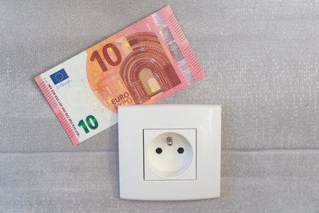 Banknote and socket as concept for the price of electricity