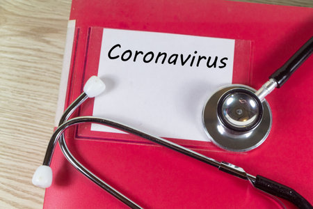 File with coronavirus and stethoscope in a medical officeの写真素材