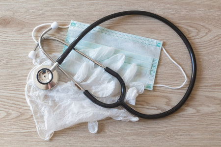 Green medical mask, stethoscope and latex gloves for protection against virusの写真素材