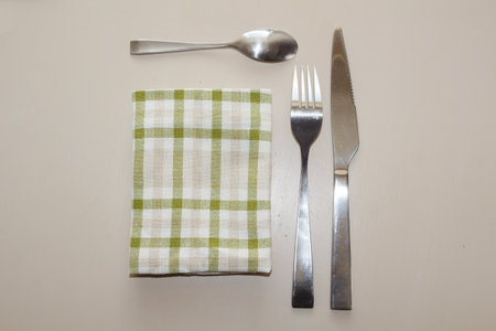 Fork, knife, teaspoon and green and white napkinの写真素材