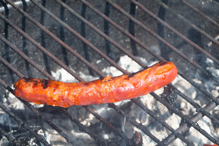 Merguez grilling on the grid of a barbecue during summer