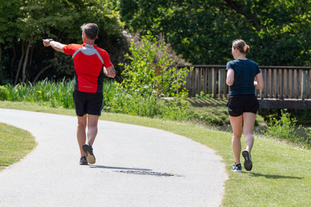 Guipavas â France, May 18, 2018 : Couple running in a park during a sunny dayのeditorial素材