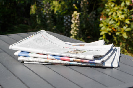 Pile of newspapers on a table in a garden