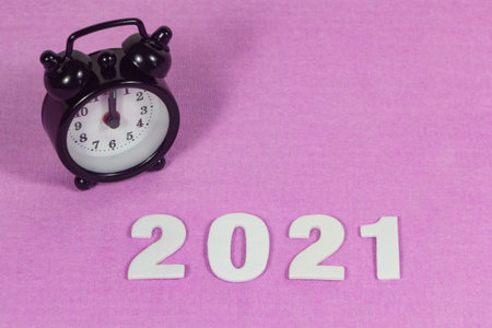 2021 in white figures and black alarm clock on pink backgroundの写真素材