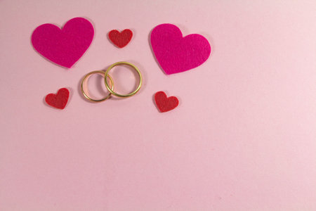 Two wedding rings and pink hearts for Valentine's dayの写真素材