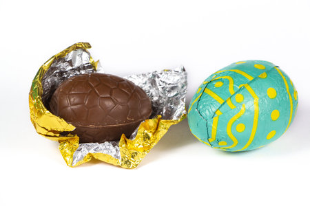 Milk chocolate eggs wrapped in golden and green paper for easterの写真素材