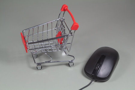 Small shopping cart and mouse as concept for buying on internetの写真素材