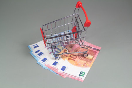Small shopping cart and banknotes of ten and twenty eurosの写真素材