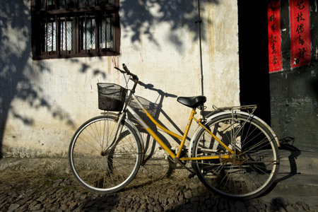 Old bicycle leaning against a old wall の写真素材