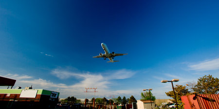 passenger plane fly down over take-off runway from airport の写真素材