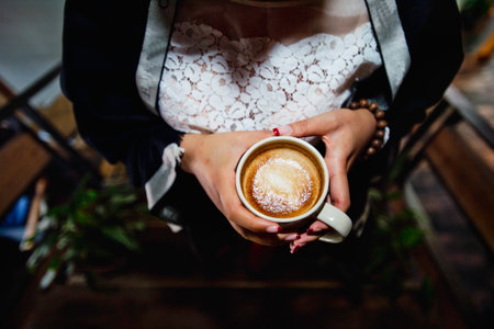 Hands of woman holding cup of coffeeの写真素材