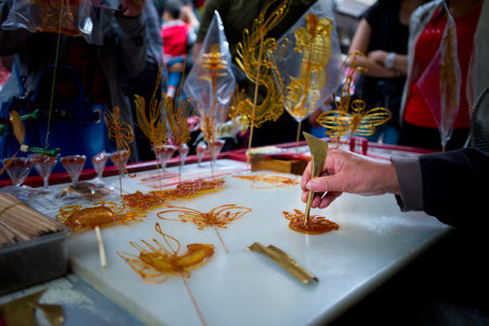 Craftsman at Jinli Street in Chengdu is making butterfly lollipops at the main alley of the street which are to be sold to the tourists.Chengdu, China - oct 8, 2014のeditorial素材