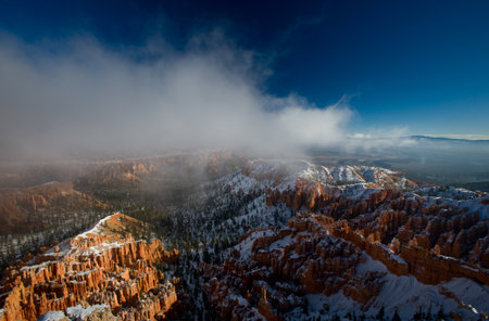 Bryce canyon panorama with snow and fog in Winter with red rocks and blue sky.の写真素材