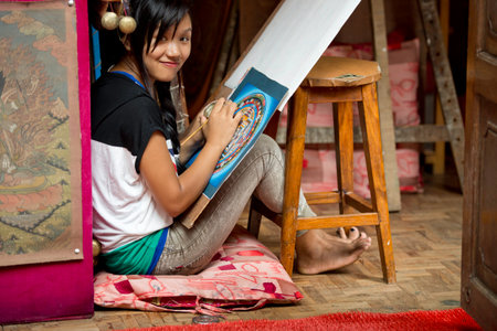 A young artist paints a Tibetan tanka painting in Bhaktapur, Nepalのeditorial素材