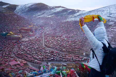 Man travels in the Tibetan Buddhist Academy in snowy days, Sichuan, Chinaの写真素材