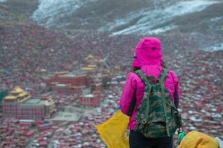 Tourists standing on the mountain, the background is Sichuan Buddhist College, Chinaのeditorial素材