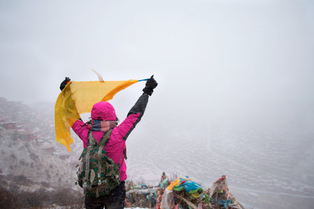 Tourists standing on the mountain, the background is Sichuan Buddhist College, China