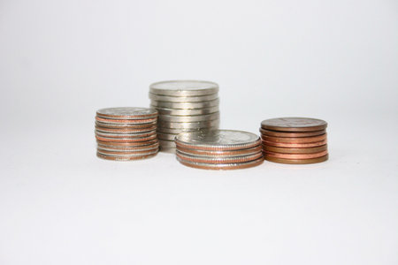 Stacked Quarters, Nickels, Dimes, Pennies against white background