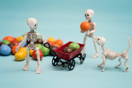 Two skeleton kids and skeleton dog getting chocolate candyの写真素材