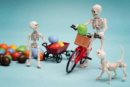 Skeleton and his skeleton kid getting chocolate candy with bicycleの写真素材