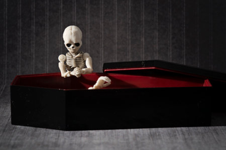 Little skeleton kneeling at the coffinの写真素材