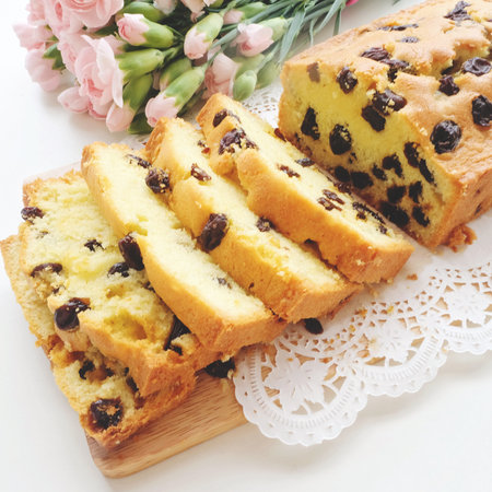 Home made raisins sponge cake and pink flowersの写真素材