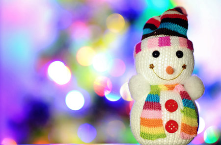 Toy snowman and Christmas lights in the backgroundの写真素材