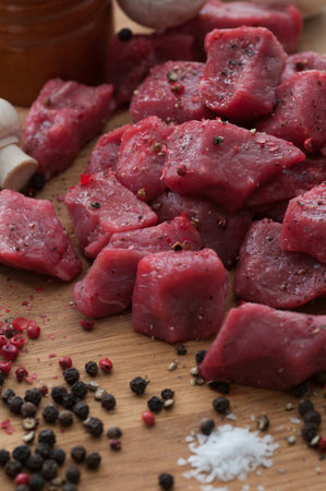 Raw beef cut into cubes. spiced with pepper and sea salt.の写真素材