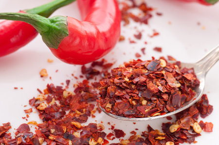 Spoon with red chili pepper flakes.の写真素材