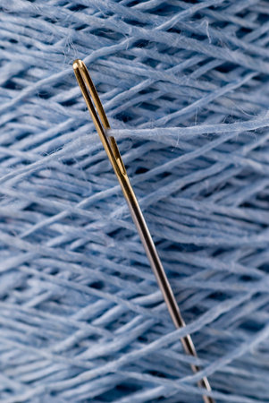 Sewing needle with light blue flax yarn on a spool.の写真素材