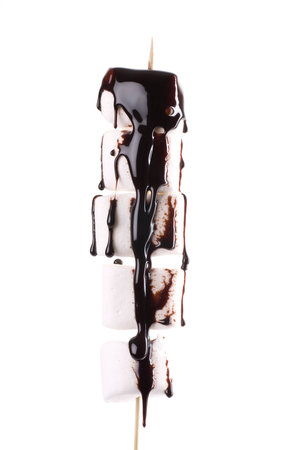 Marshmallows with chocolate sauce on a wooden stick.の写真素材