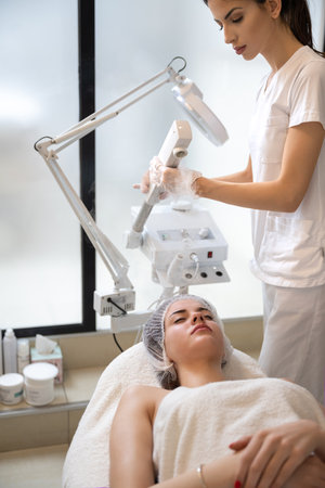 Beautiful woman having ozone therapy with facial steamer in beauty salon.の写真素材