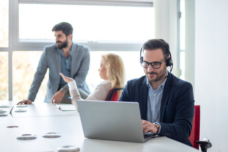 Young male technical support dispatcher in call center. Man in call center with headset helping...