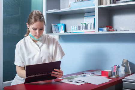 Female dentist checking appointments in dental officeの写真素材