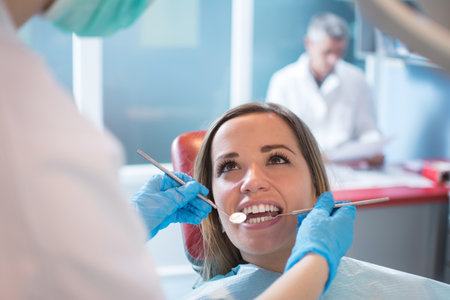 Dentist examining a patients teeth in the dental officeの写真素材