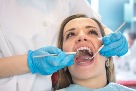 Dentist examining a patients teeth in the dental officeの写真素材