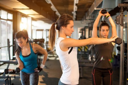 Three pretty girls workout in the gymの写真素材