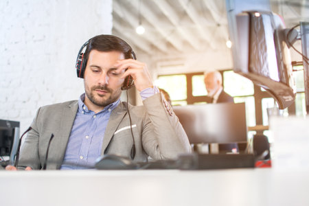Tired call center operator having a headache in office.